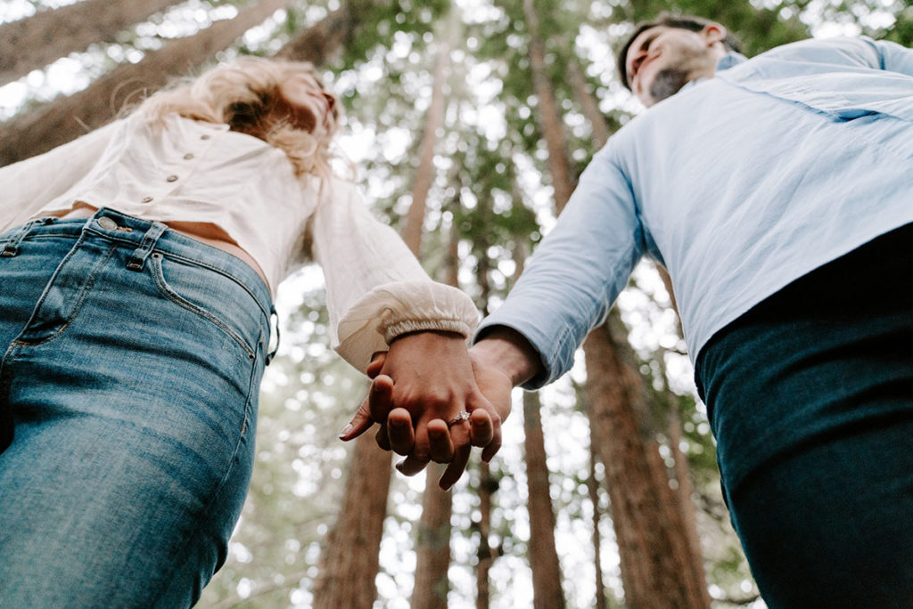 A couple demonstrates how Yes, And therapy exercise bonds you by holding hands in nature.