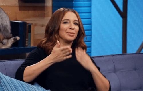 Maya Rudolph blowing kisses, making a heart with her hands, and winking.