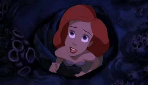 Ariel from "The Little Mermaid" (animated version) extends her hand through a hole in the sea ground, longing to be a human.