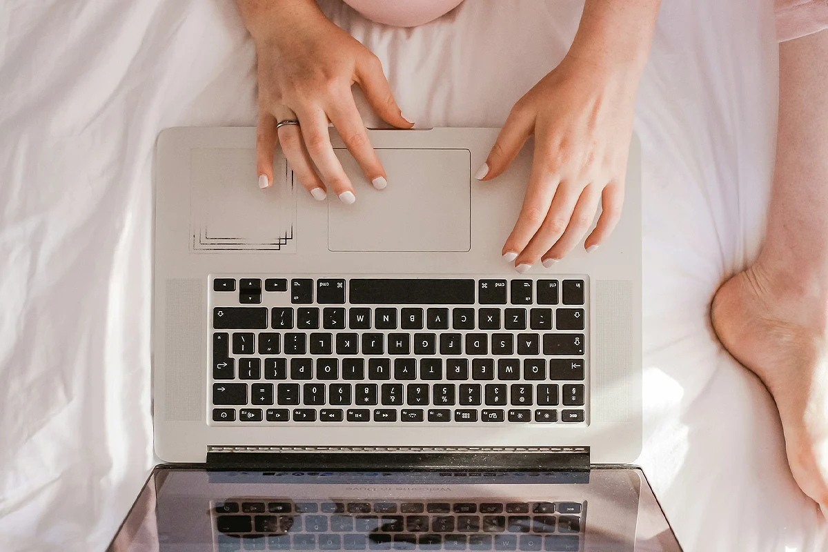 A woman's hands on a laptop keyboard, a ring on her finger, trying to find a couples therapist.