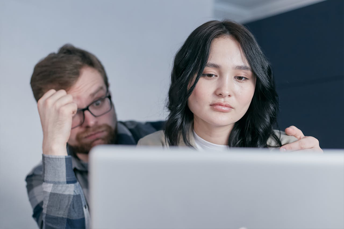 A couple looking at a computer, as if using a task management system like trello or notion for their relationship.