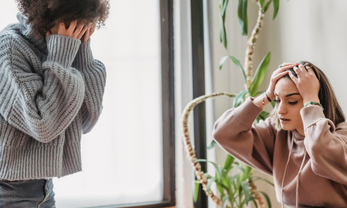 Two women in a toxic relationship hold their heads in frustration, wondering if their toxic relationship can really be fixed.